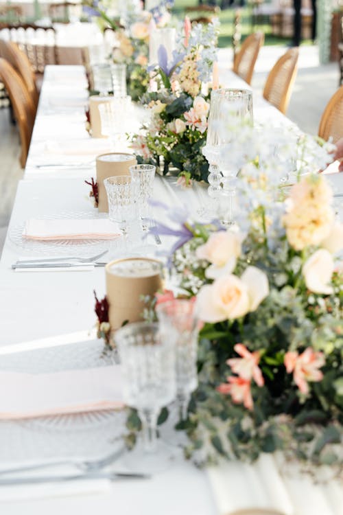 A long table with white linens and flowers