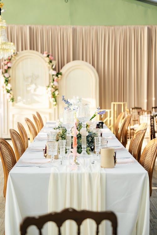 A long table with white linens and flowers