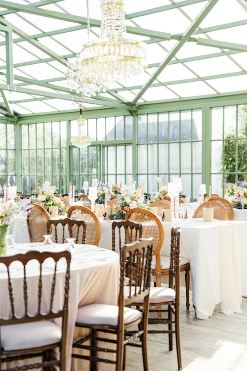 A wedding reception in a greenhouse with chandeliers