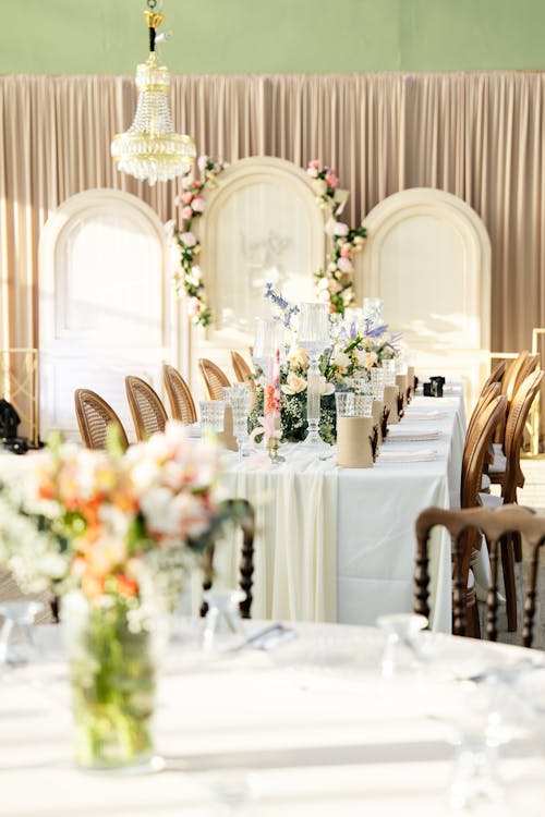 A long table with white linens and flowers
