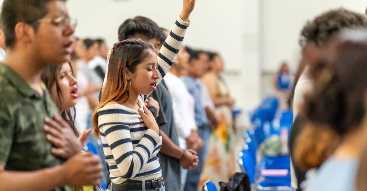A vibrant Sunday morning worship service at Christ Embassy Ho with people actively singing and raising hands