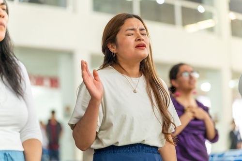 Free A woman deeply engrossed in prayer during a church gathering in Ciudad de México. Stock Photo