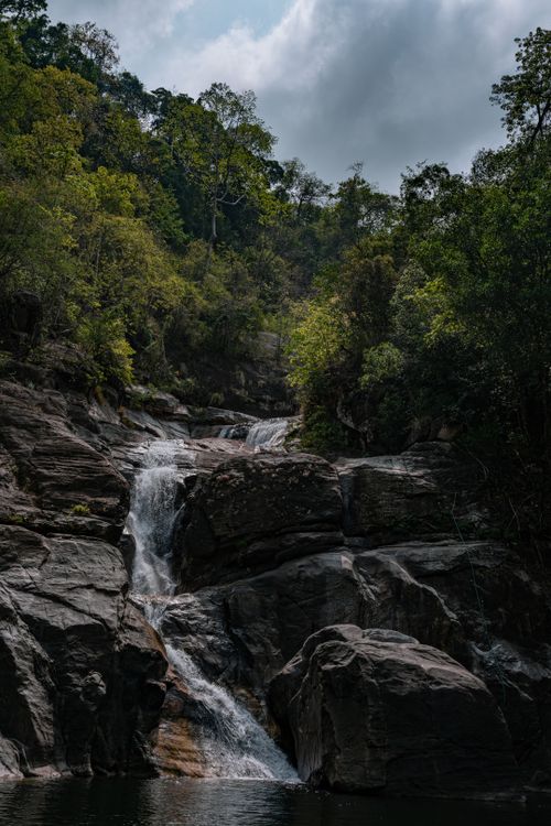 Free Serene waterfall cascading through lush Kallar forest in summer, Kerala, India. Stock Photo