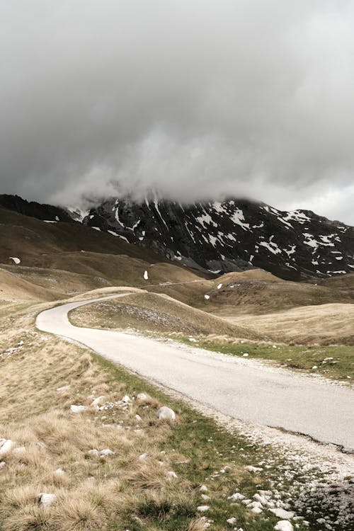 A road in the mountains with a cloudy sky