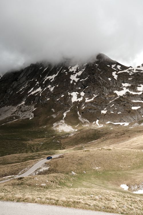Free A winding road through snowy mountains in Žabljak, Montenegro, under a cloudy sky. Stock Photo