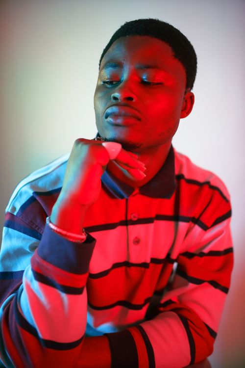 Free Studio portrait of a man with red lighting, showcasing fashion style in Birmingham. Stock Photo