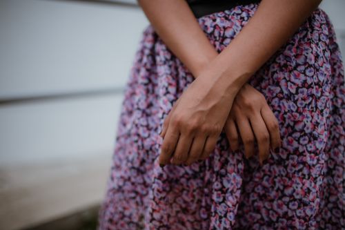 Free Close-up of hands on a floral dress, showcasing elegant fashion and style. Stock Photo