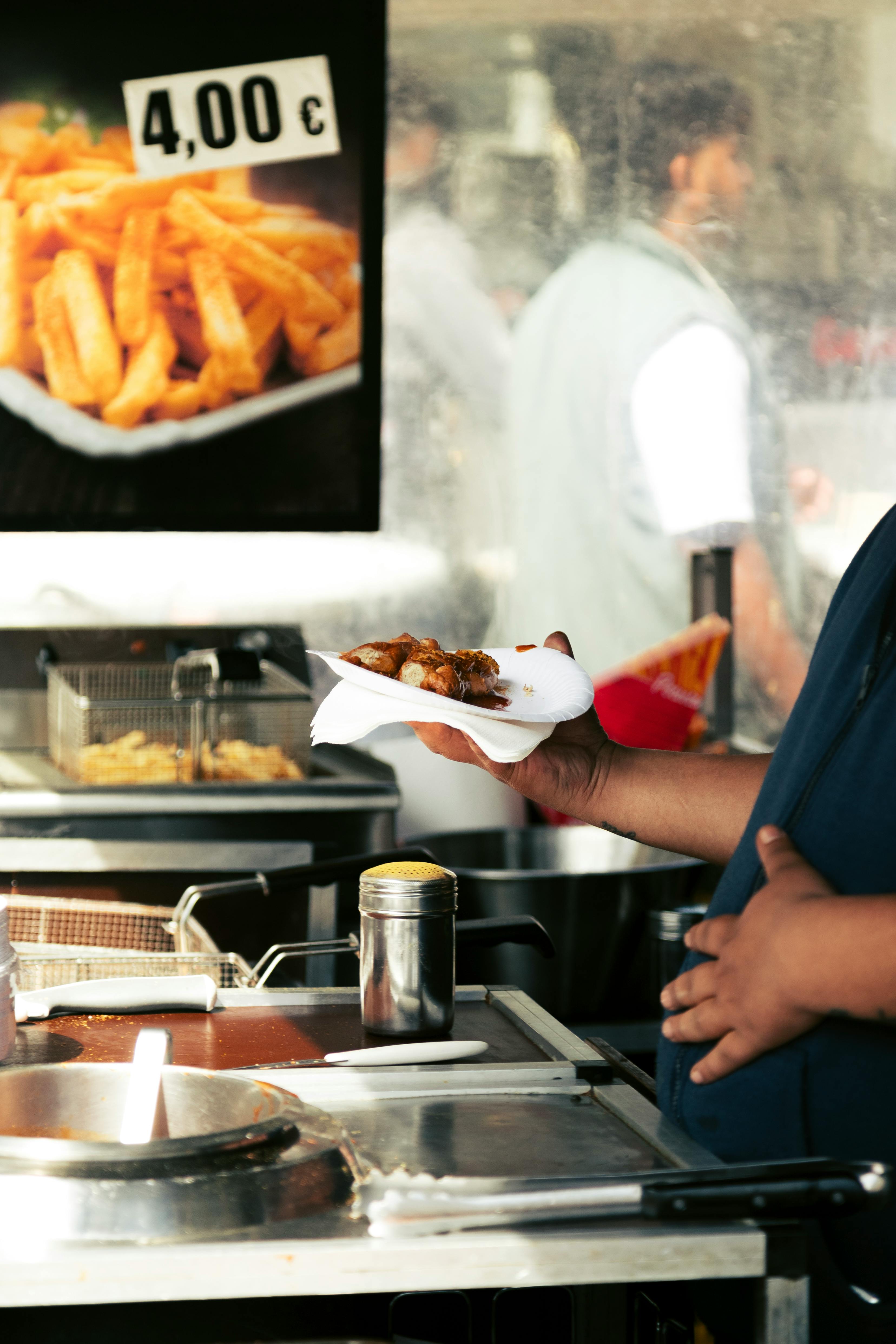 A vendor hands over fresh street food at an outdoor market in Berlin.