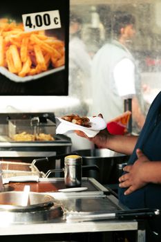 A vendor hands over fresh street food at an outdoor market in Berlin.