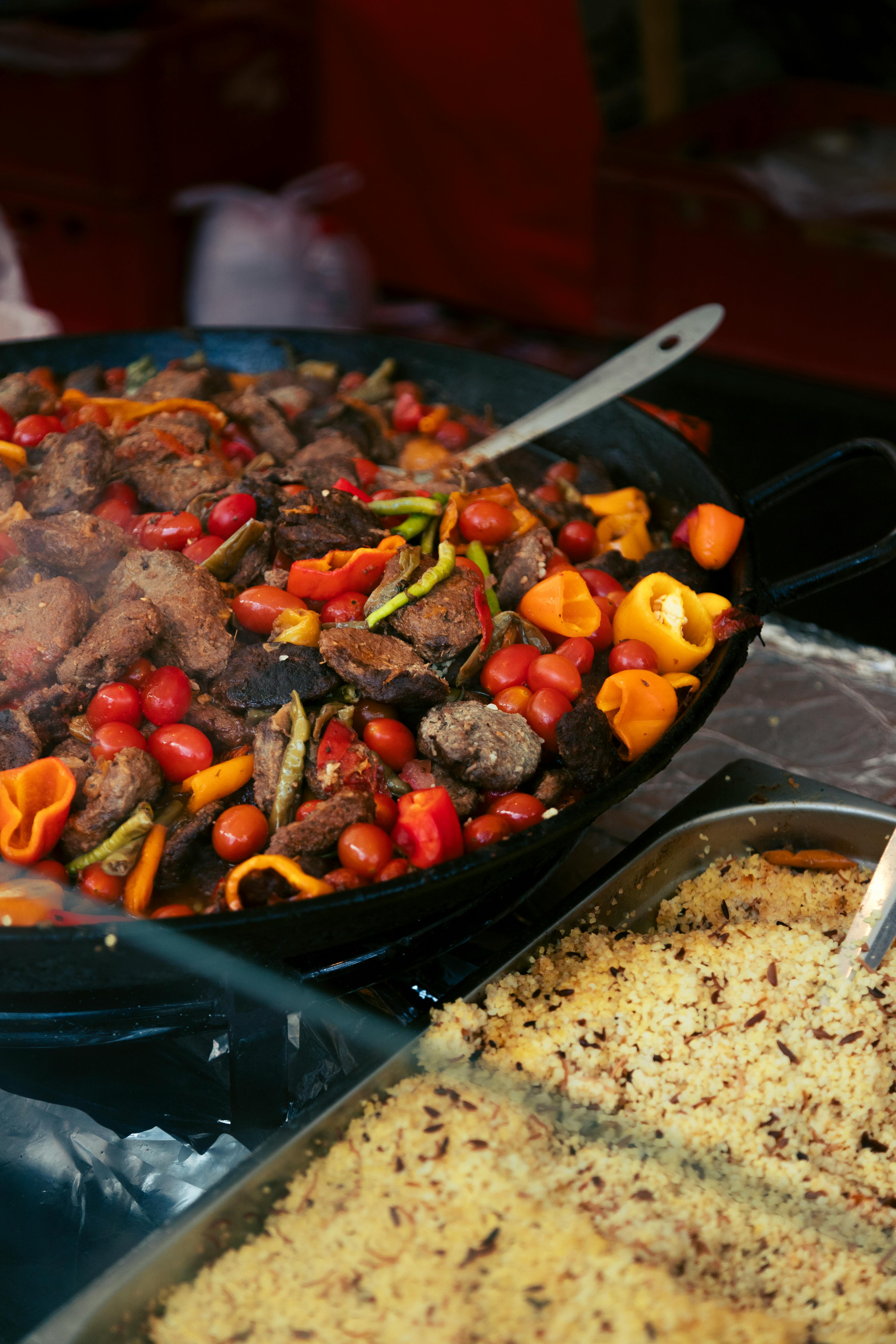 A vibrant stir-fry with mixed vegetables and beef paired with couscous in a Berlin market setting.