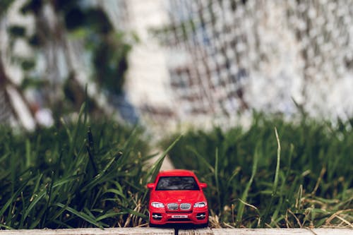 Free Red Car Toy on Green Grass Stock Photo