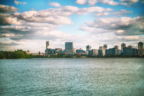 A city skyline is seen from a lake