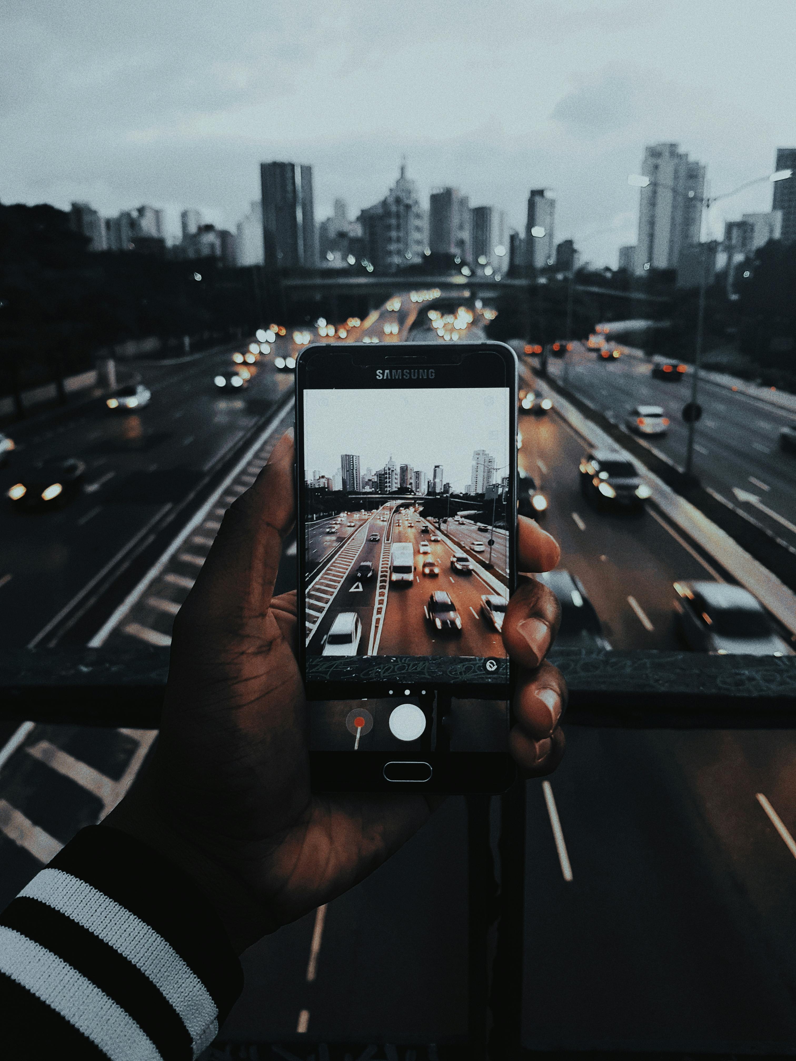 person taking photo of cars on road