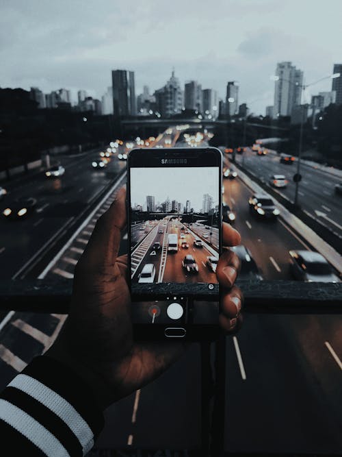 Free Person Taking Photo of Cars on Road Stock Photo