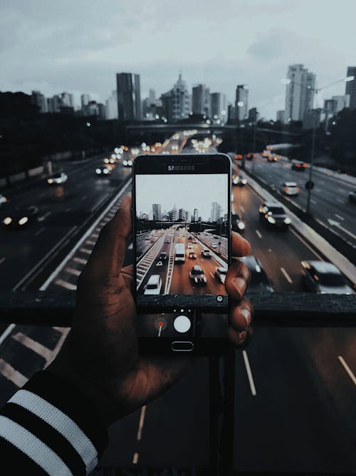 Person, Die Fotos Von Autos Auf Der Straße Macht