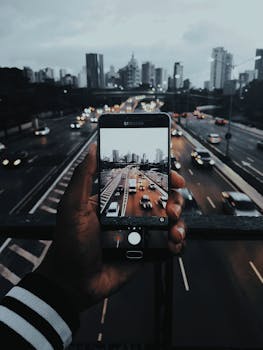 在繁忙的高速公路上，用手机镜头捕捉圣保罗暮光时分的活力城市景观