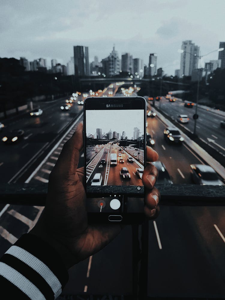 Person Taking Photo Of Cars On Road