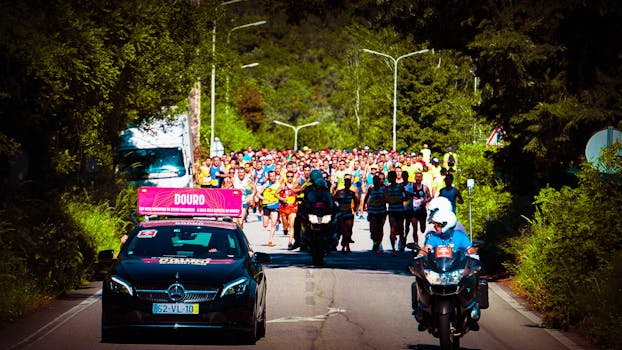 前方拍摄到一大群参加户外马拉松的跑步者，视野中可以看到支持车辆