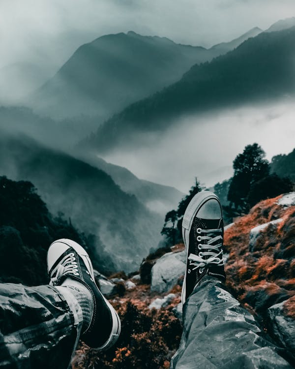Free Man Sitting on a Mountain Cliff Stock Photo