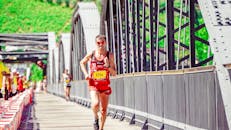 在一个阳光明媚的日子，跑步者在明亮的马拉松赛道上展现了耐力和运动能力