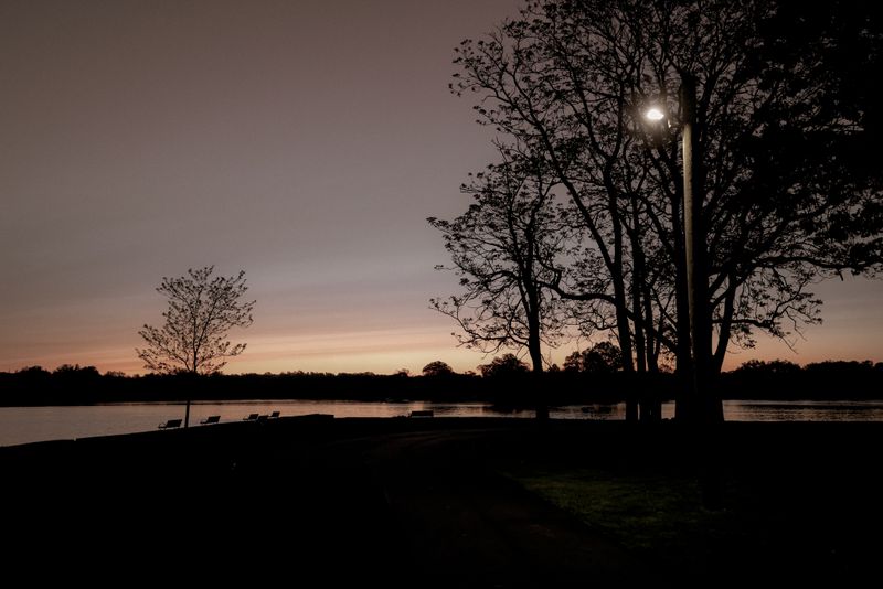 Empty bench facing a lake at sunset — David Kanigan on Pexels