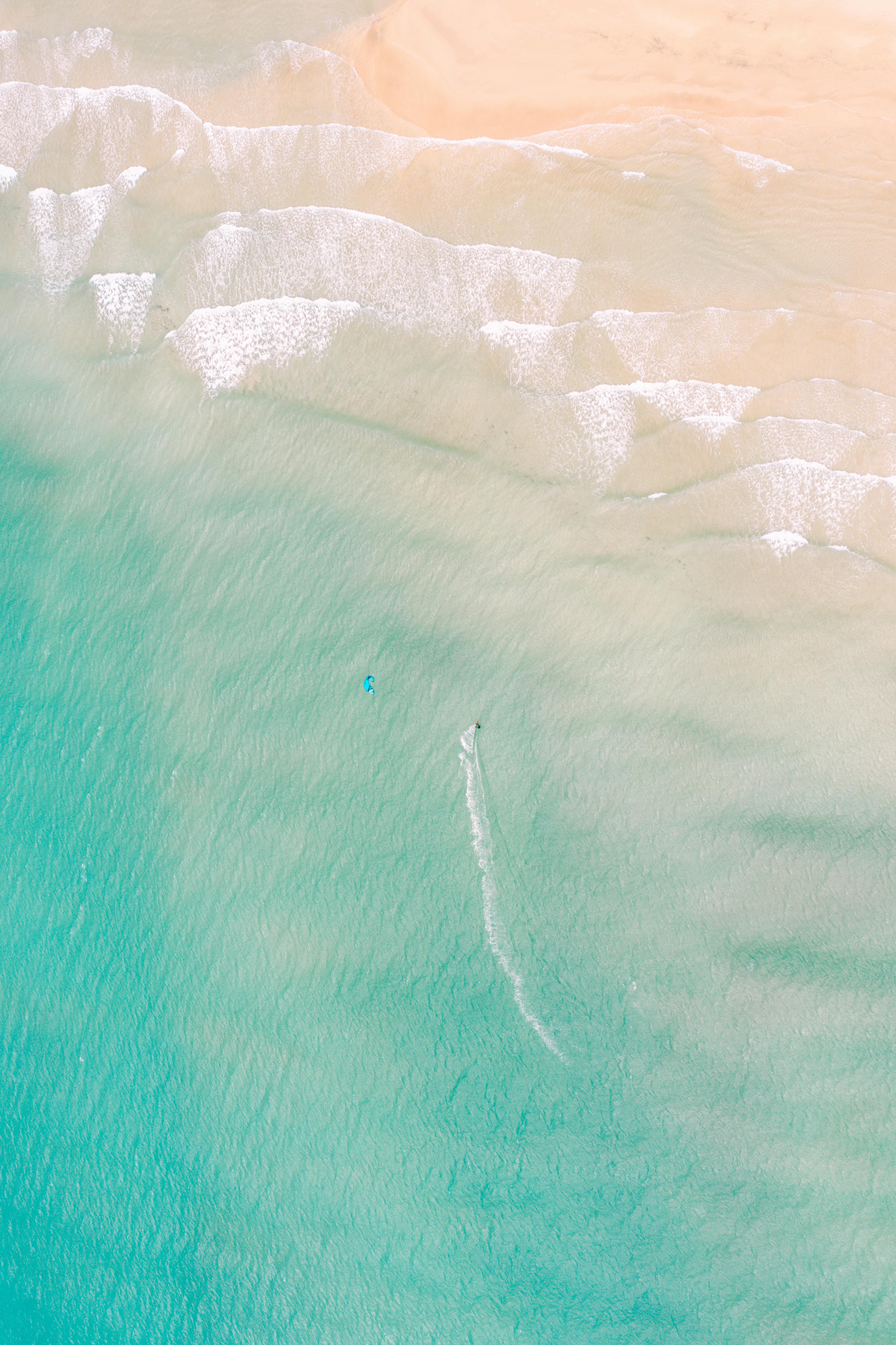 Stunning aerial view of El Cotillo beach in Spain showcasing turquoise waters and wave patterns perfect for surfing.