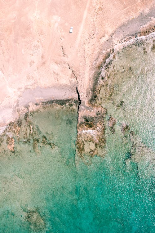 An aerial view of a beach with a cliff