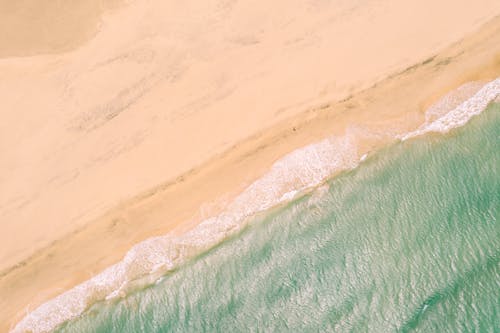 Aerial view of a beach with waves and sand