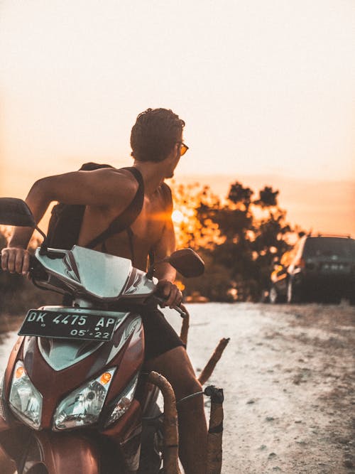 Topless Man Riding Motor Scooter