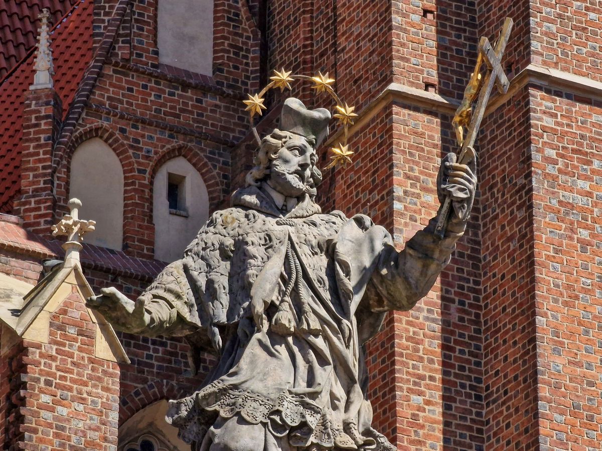 Statuie baroca pe fond de zid de caramida