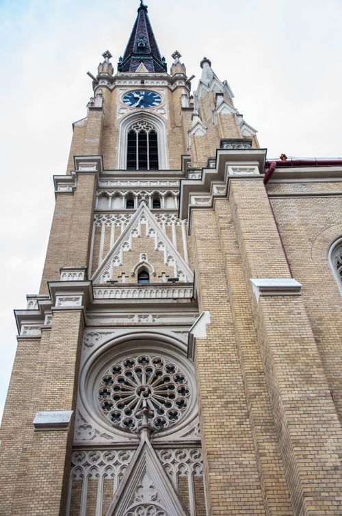 Free Low angle shot of a historic church tower in Novi Sad, Serbia, showcasing intricate architecture. Stock Photo
