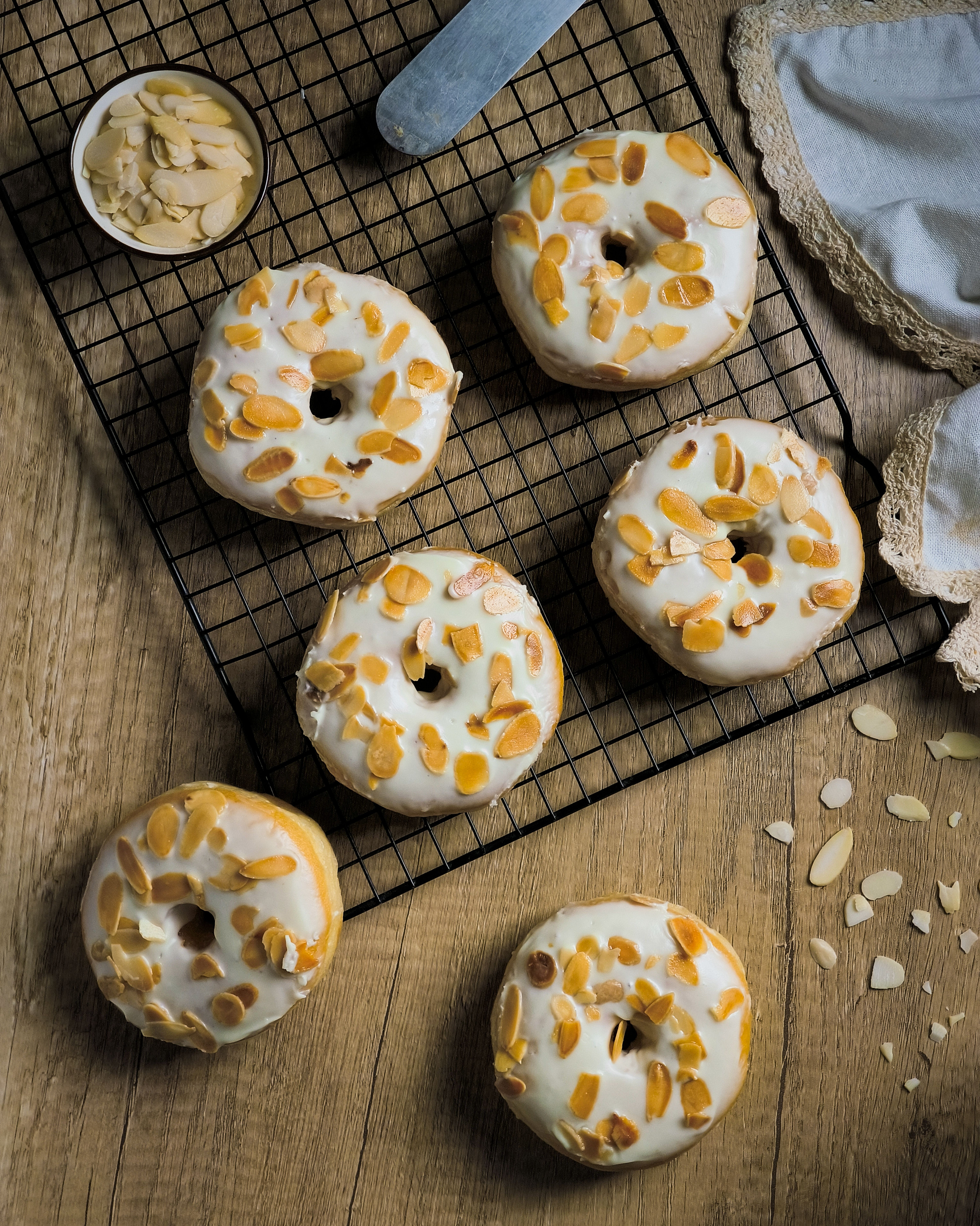 Almond glazed donuts on a cooling rack
