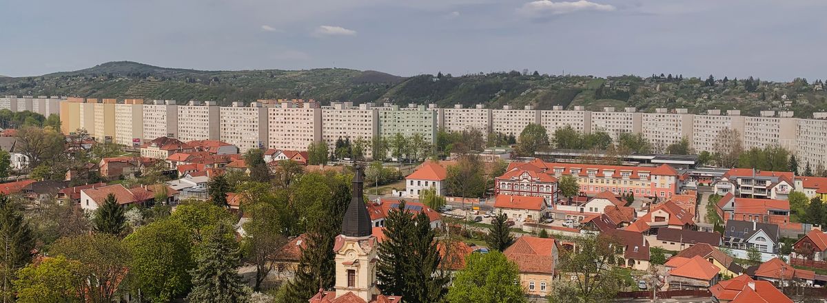 Aerial view of Miskolc, Hungary showcasing apartment buildings, lush greenery, and urban landscape.