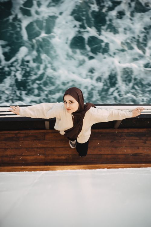 Free A young woman stands on a boat deck enjoying the view, with the sea behind her in Istanbul. Stock Photo