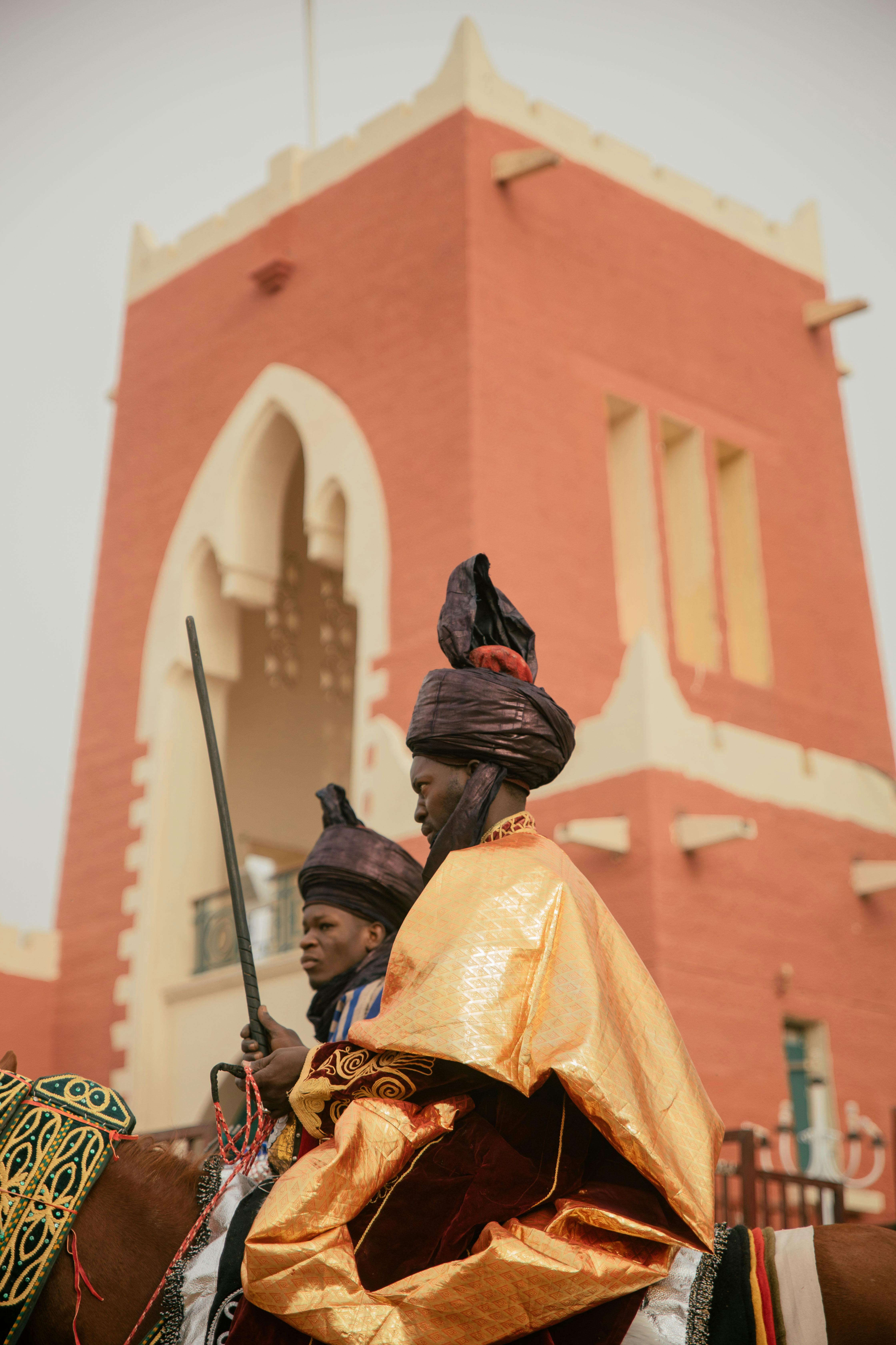 men in traditional clothing near tower