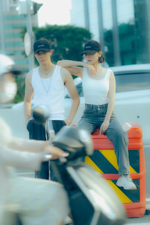 Two people sitting on a red box on the street