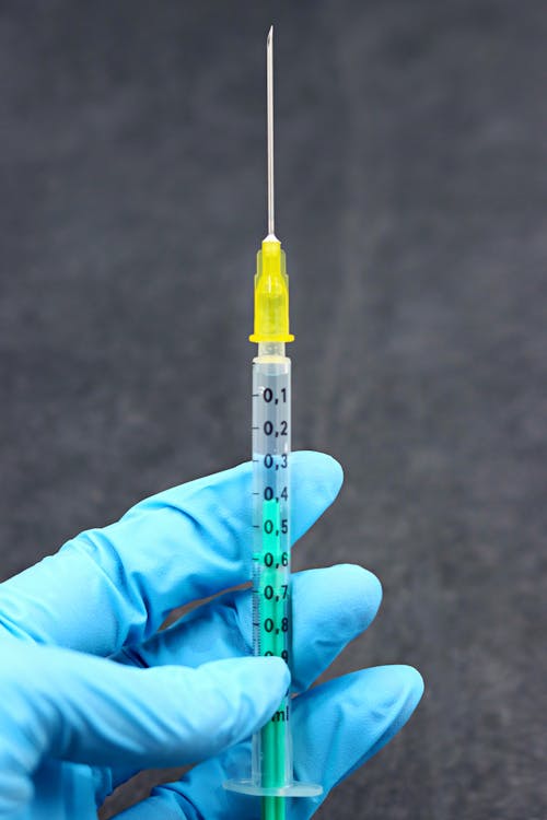 Medical Person Holding a 1ml Syringe with Needle