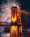 绚丽的烟花在标志性的城市桥梁上空绽放，照亮夜空，呈现出一派生机勃勃的景象