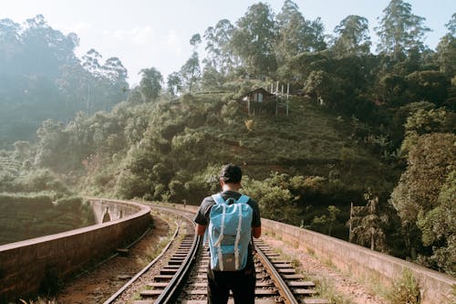 Foto De Vista Posterior De Un Hombre Parado En Medio De Una Vía De Tren