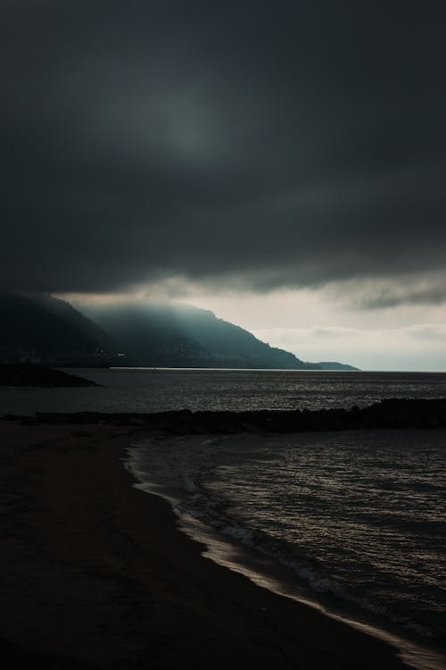 A dark sky over the ocean and mountains