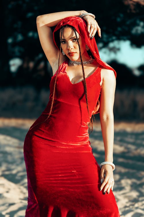 Portrait of Brunette Woman in Red Dress and Veil Standing with Arm Raised