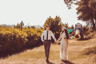 Photo of Couple Holding Hands While Walking