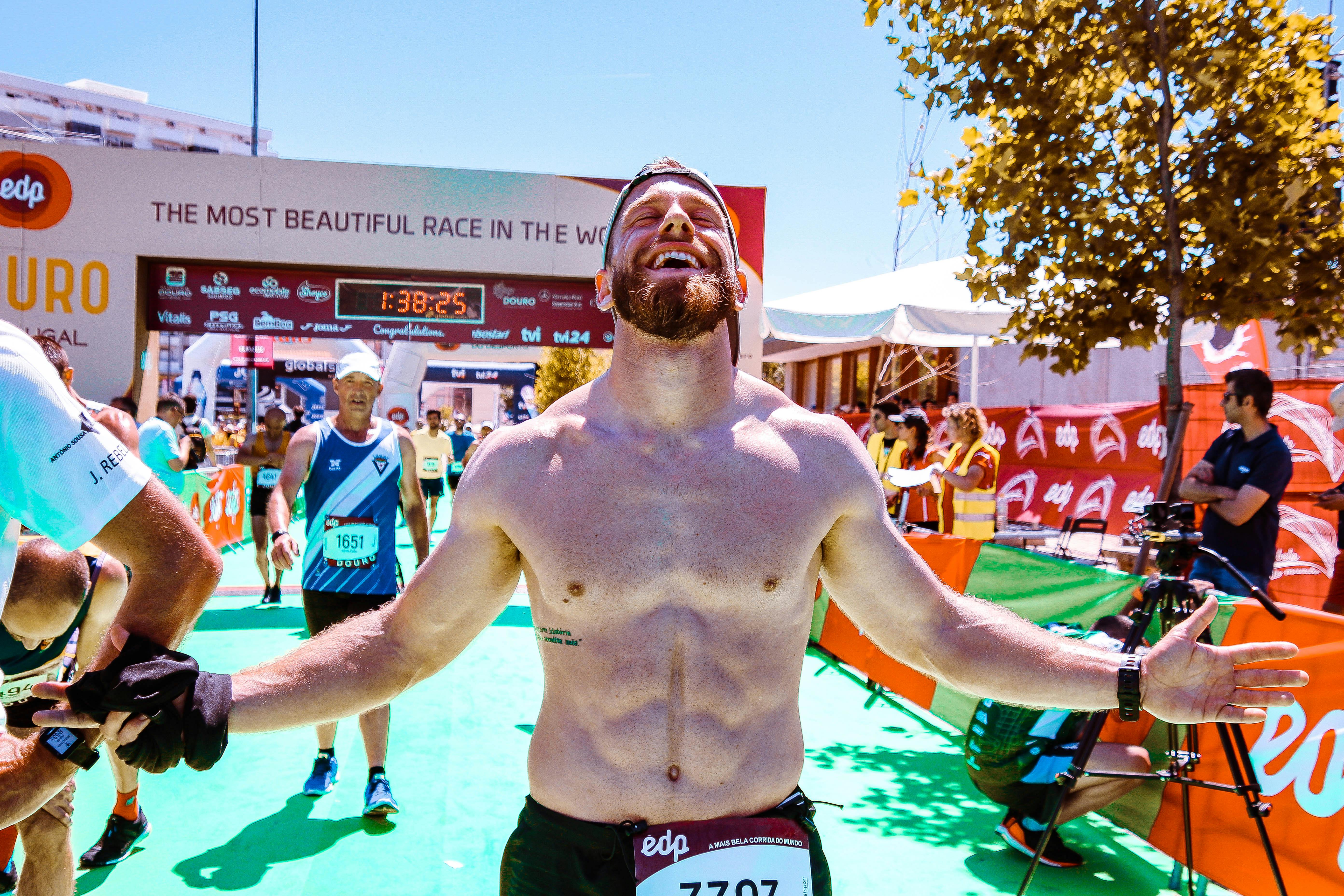 一名跑步者在马拉松比赛的终点线欢呼，庆祝胜利凯旋