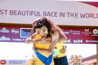 在比赛终点线，两名跑步者深情拥抱