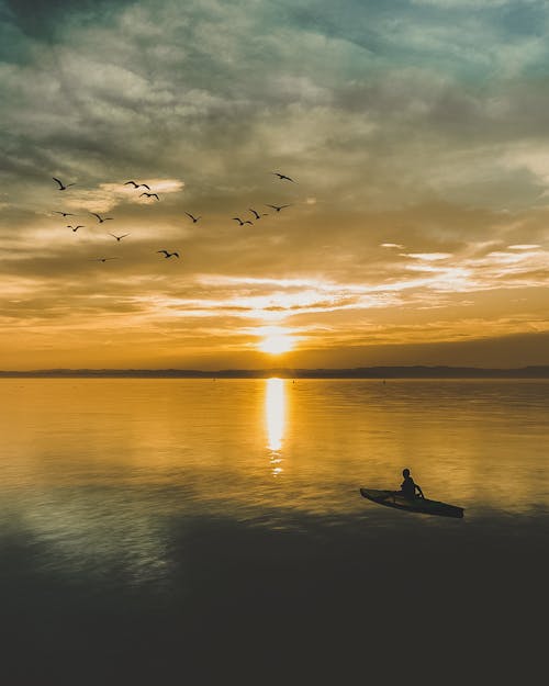 Foto Di Una Persona In Barca Durante L'ora D'oro