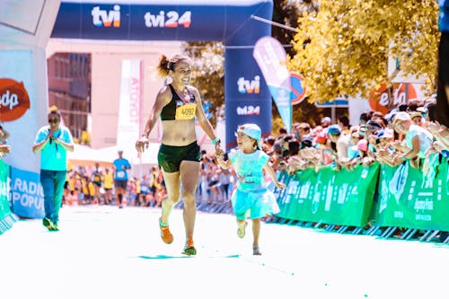 Photo of Woman Running Beside Her Child