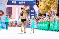 一对快乐的母女手拉手冲过马拉松终点线，幸福和活力洋溢全身