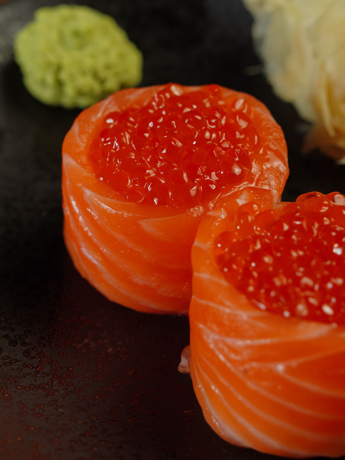 An extreme close-up shot of a sushi roll, with the rice and filling visible, and the nori seaweed wrapping it neatly