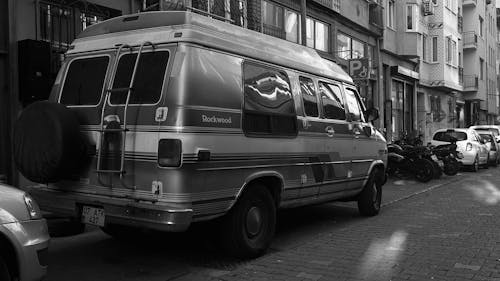 A black and white photo of a van parked on the street