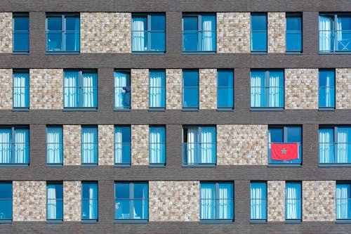 A building with many windows and a red flag